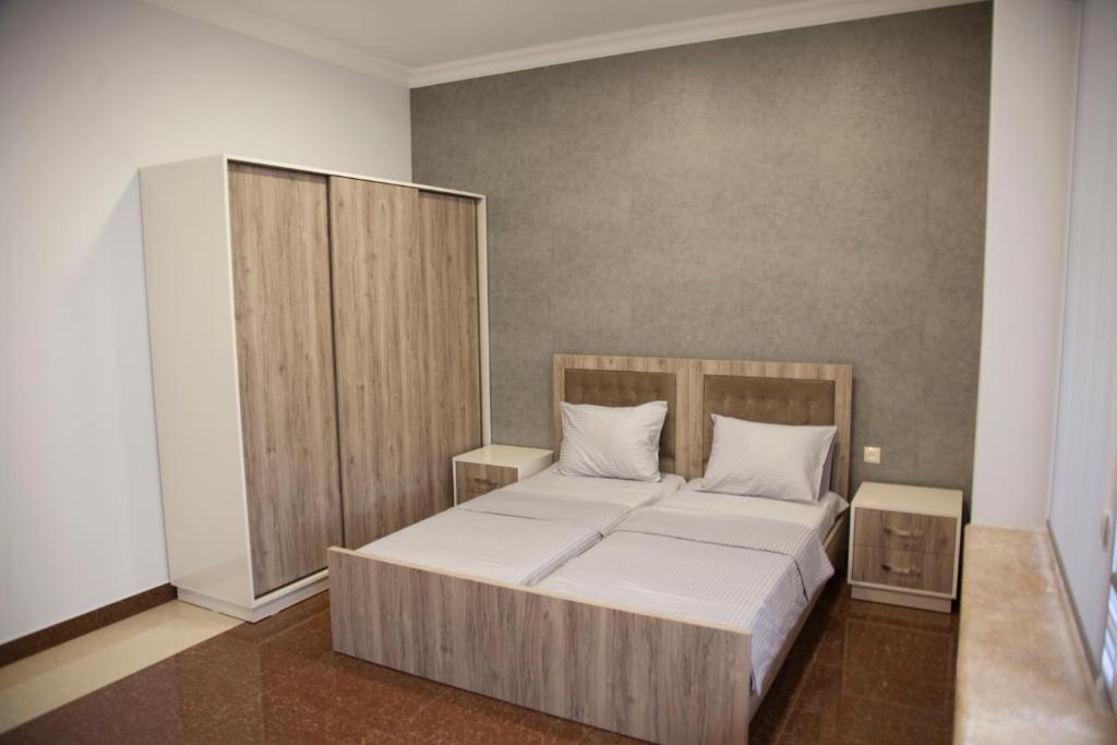 a bedroom with a bed with a wooden headboard at Liko Hostel in Yerevan