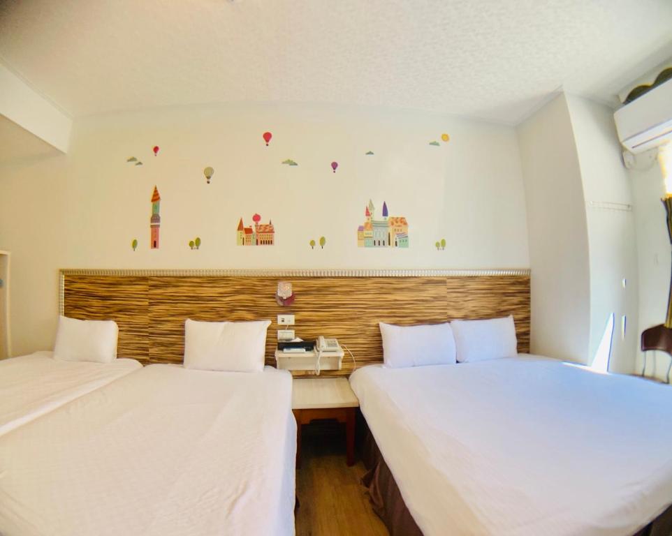 two beds sitting next to each other in a room at Dung Shin Hotel in Taitung City