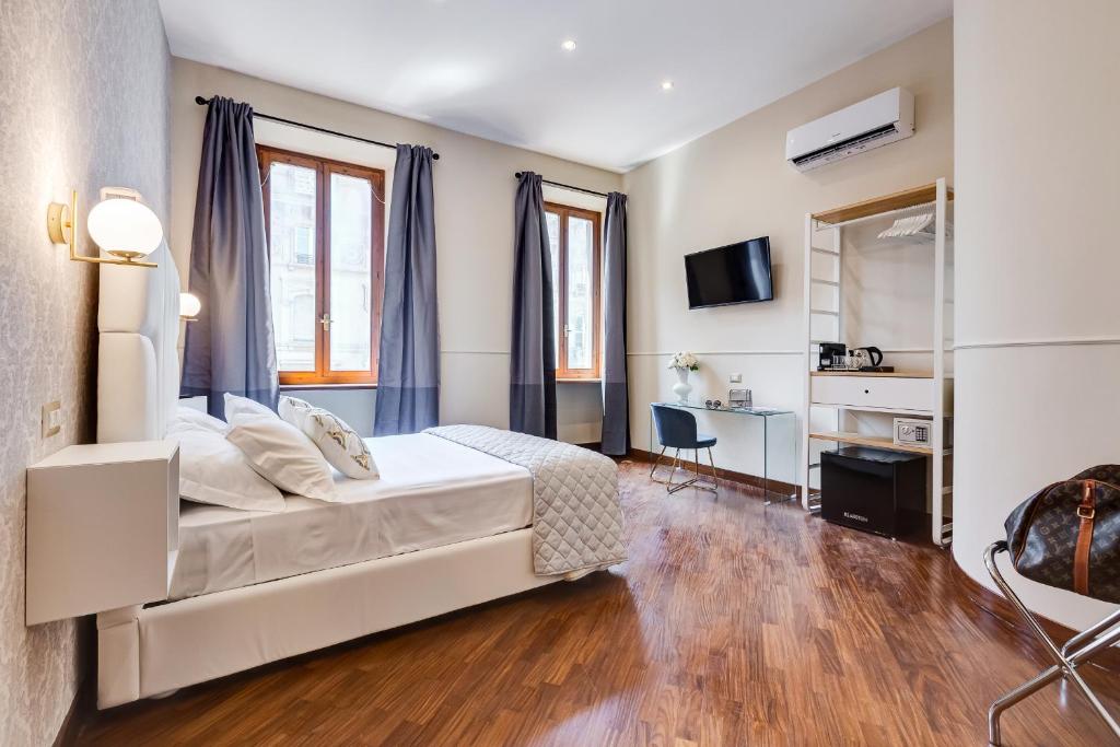 1 dormitorio con 1 cama blanca grande y escritorio en Trevi Private Suites by Premium Suites Collection, en Roma