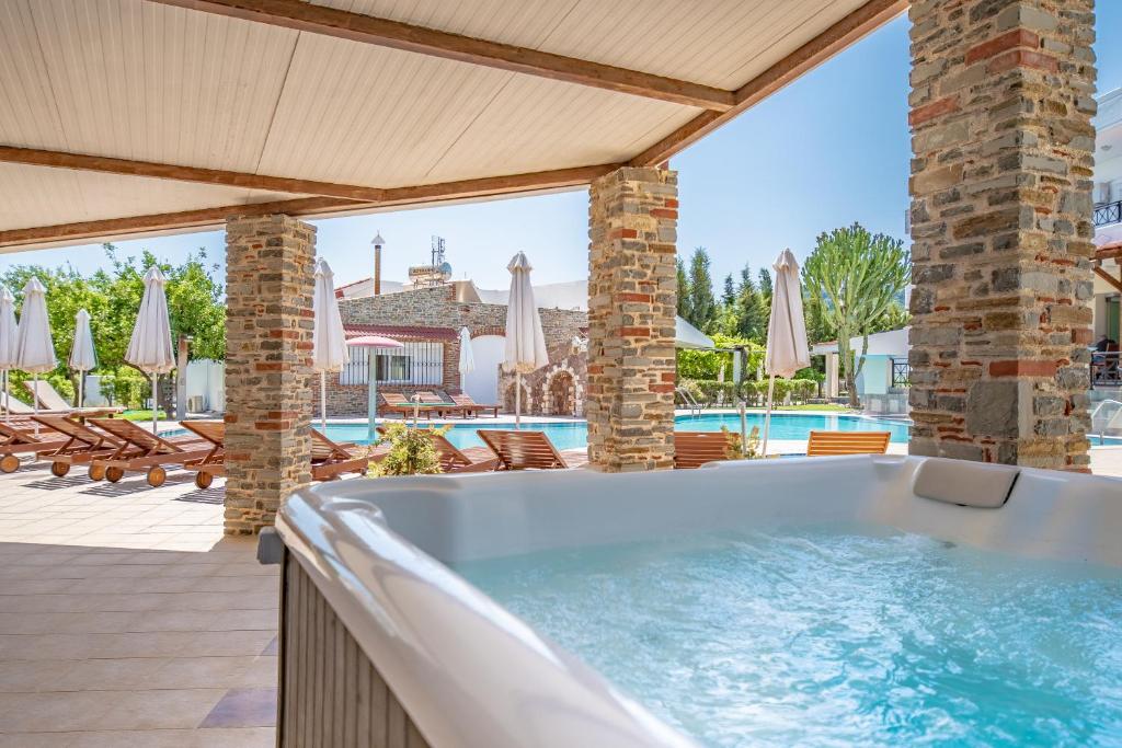 a hot tub in a patio with a pool at Bright Star in Faliraki