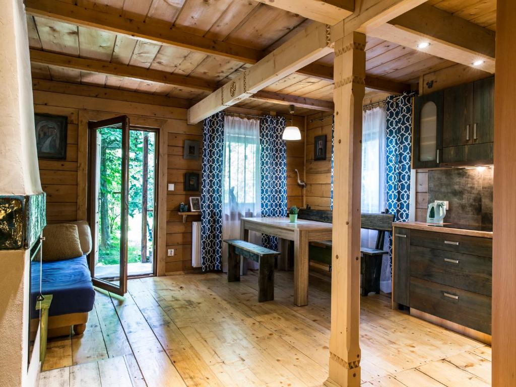 a kitchen with wooden walls and a wooden floor at Dom drewniany Ozwa in Gronków