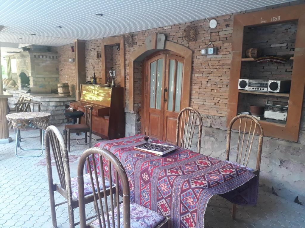 a table and chairs with a table and a kitchen at Aghveran Eco Guest House in Tkhit
