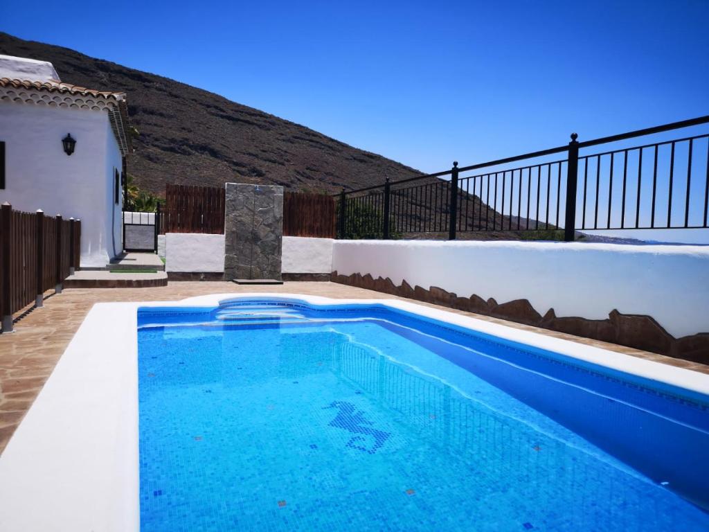 a blue swimming pool in the backyard of a house at Sunset Las Hadas in Candelaria