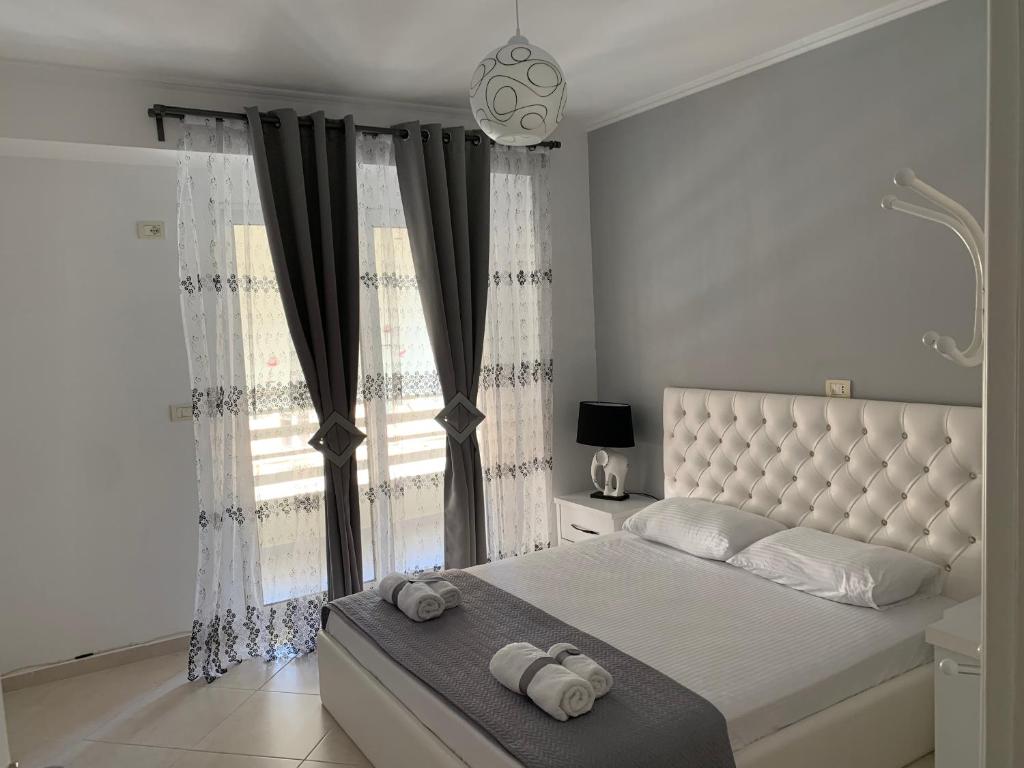 a bedroom with a large bed with two towels on it at Marinela Apartment in Sarandë