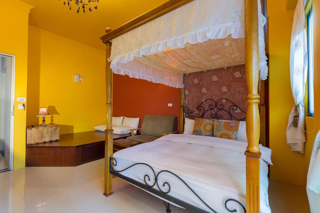 a bedroom with a canopy bed in a yellow room at 花蓮觀月民宿-寵物友善-含車位 in Hualien City