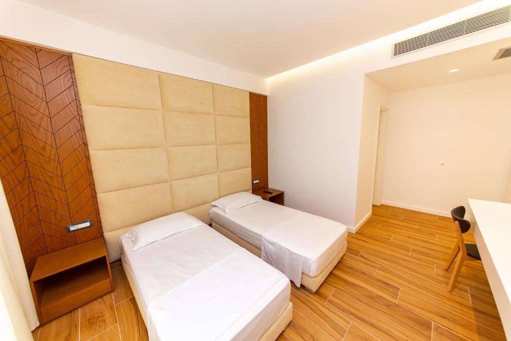 a hotel room with two beds and a desk at Inada Hotel Ksamil in Ksamil