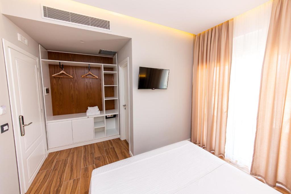 a bedroom with a bed and a tv in it at Inada Hotel Ksamil in Ksamil