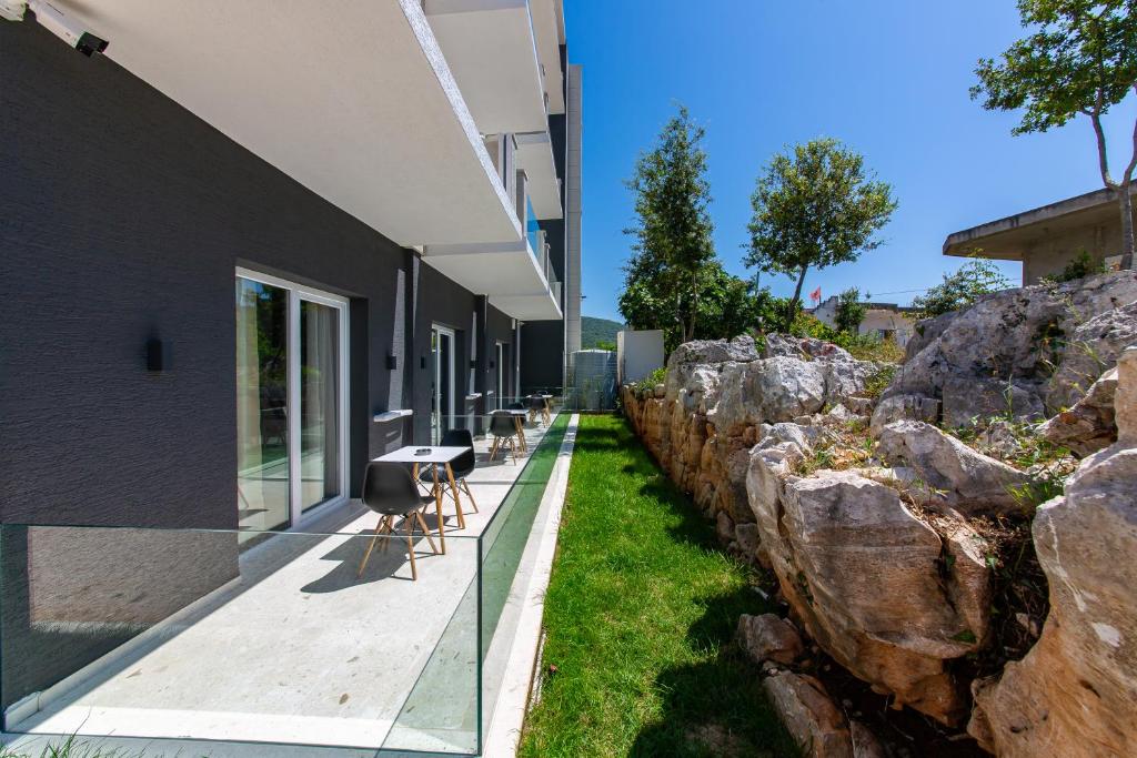 a building with a walkway next to a rock wall at Inada Hotel Ksamil in Ksamil