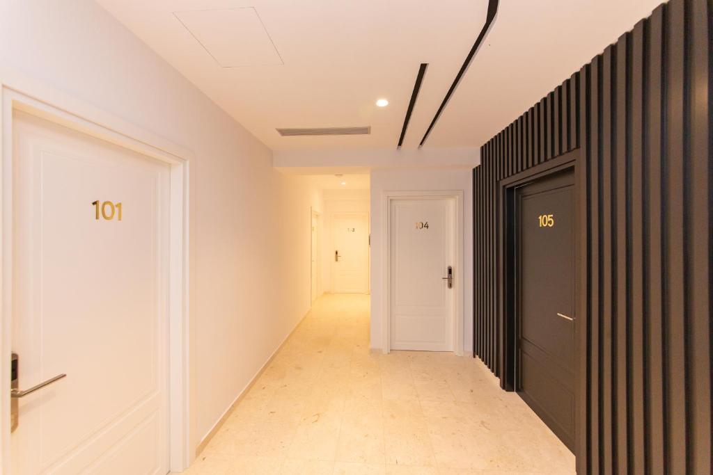 a hallway with a black and white door and a hallway at Inada Hotel Ksamil in Ksamil