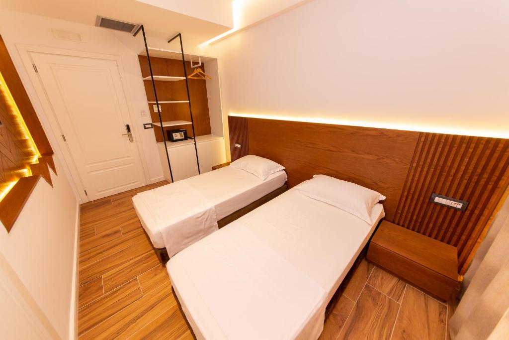 a small room with two beds and a door at Inada Hotel Ksamil in Ksamil