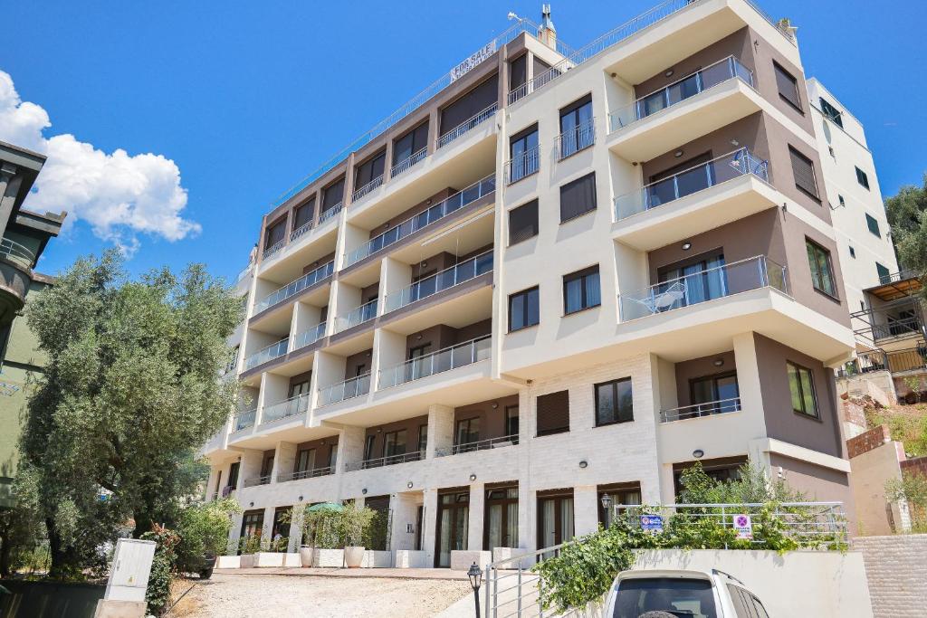 an apartment building with a car parked in front of it at Brand New Apartments - free parking in Sveti Stefan
