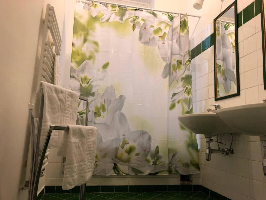 ein Badezimmer mit einer Dusche mit weißen Blumen an der Wand in der Unterkunft Centrally-Located authentic apartment in Wien