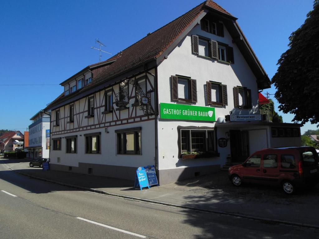 a white building with a red car parked in front of it at Grüner Baum in Stetten