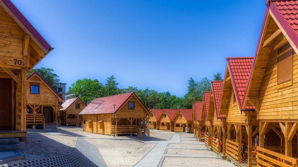 a row of wooden buildings with red roofs at Ośrodek Wypoczynkowy Nemo in Krynica Morska