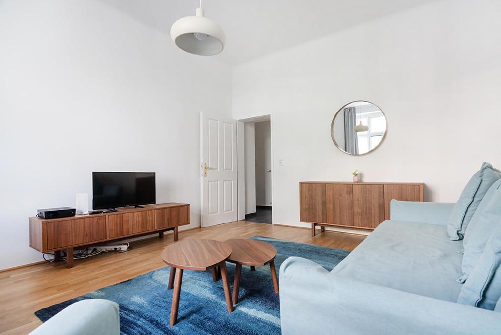 ein Wohnzimmer mit einem Sofa und einem TV in der Unterkunft UNIVERSUM APARTMENT in Wien