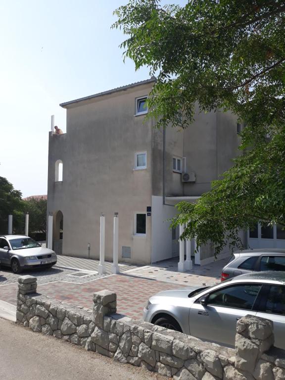 ein Gebäude mit Autos auf einem Parkplatz in der Unterkunft Apartments Erceg in Omiš