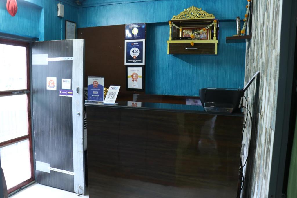 a bar in a restaurant with a blue wall at Ashirwad Guest House (Male Only) in Pune