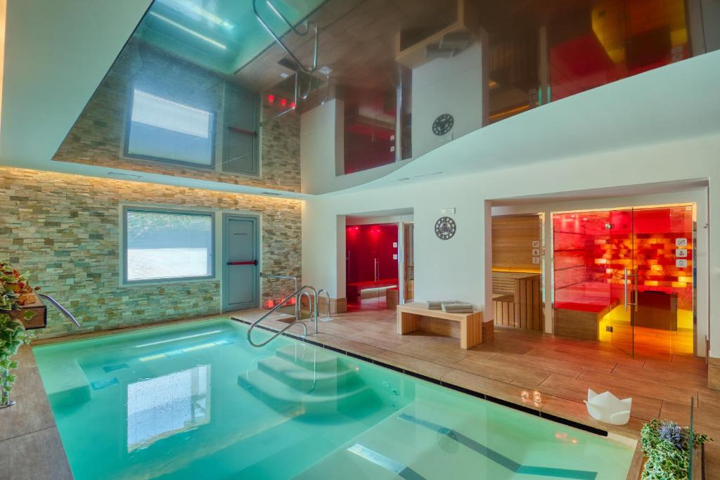 una gran piscina en una habitación con una casa en Boutique Hotel Bramante & SPA en Urbania