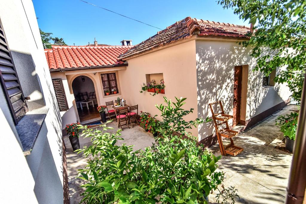 zewnętrzny widok na dom ze stołem i krzesłami w obiekcie Apartman Mare w mieście Zadar