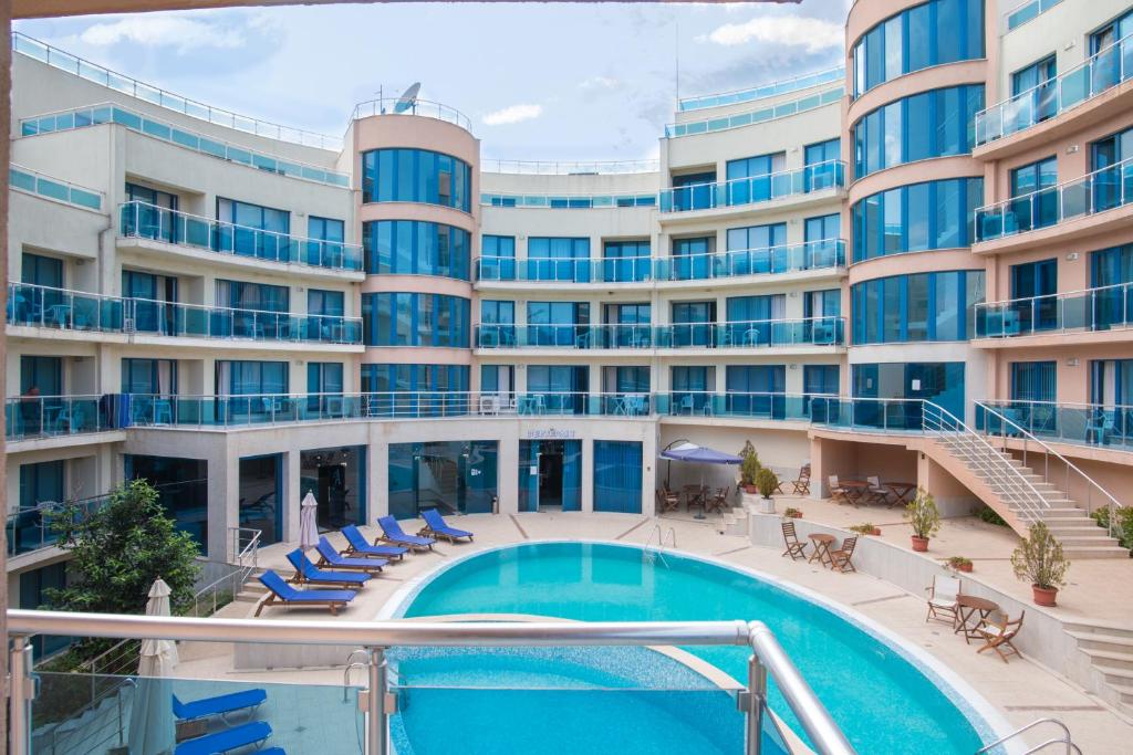a hotel with a swimming pool in front of a building at Apart Complex Aquamarine in Obzor