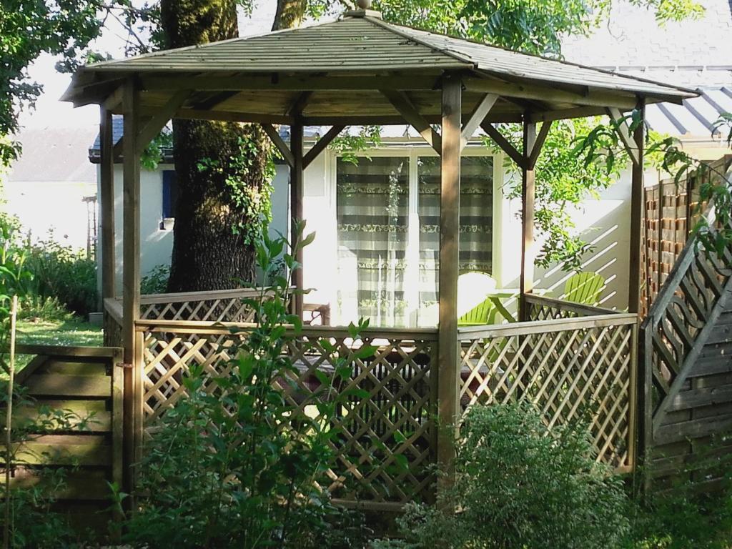 einen hölzernen Pavillon mit einem Zaun im Hof in der Unterkunft Le Nid D'Hirondelles in Donges