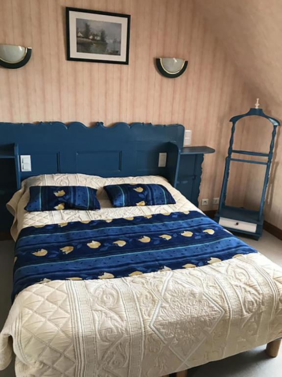 - une chambre dotée d'un lit bleu avec une tête de lit bleue dans l'établissement Gîtes du Ménez-Hom, à Plomodiern