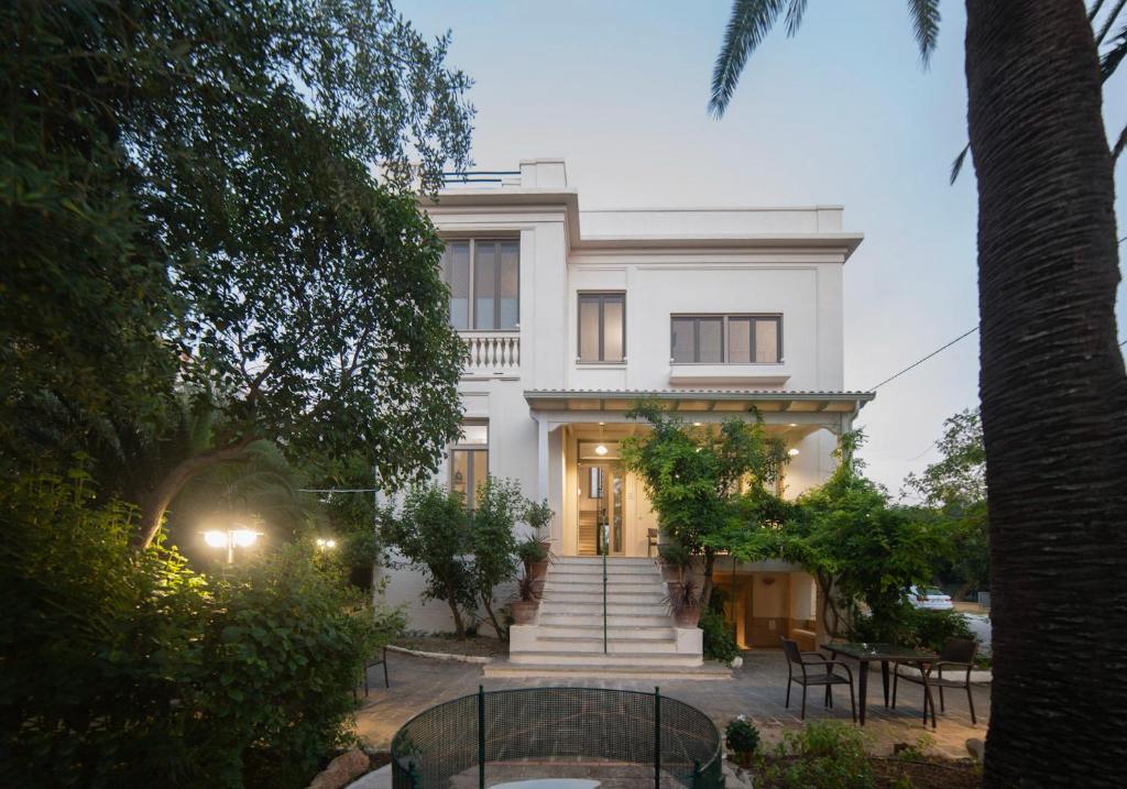 une maison blanche avec des escaliers et des tables devant elle dans l'établissement Villa Dea, à Grottaglie
