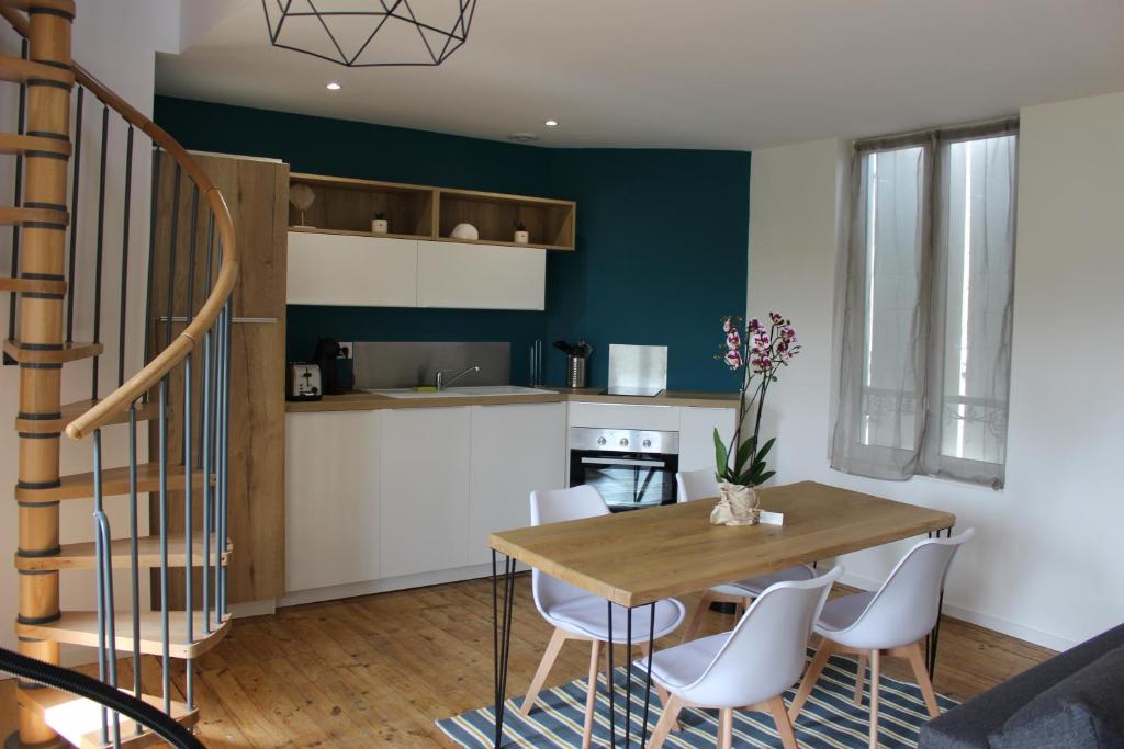 cocina y comedor con mesa y sillas en Bel appartement avec vue sur vézère, en Uzerche