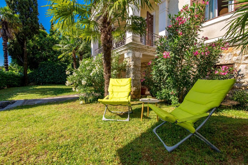 due sedie e un tavolo di fronte a una casa di Apartment Carolina a Opatija