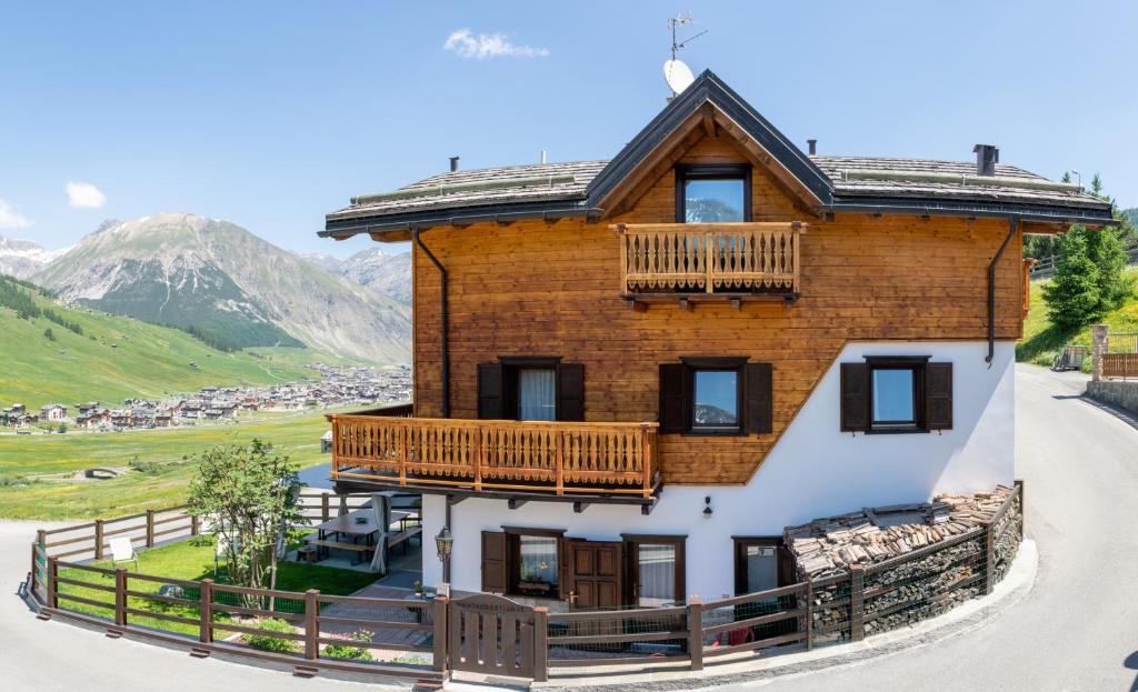 duży drewniany dom z balkonem w obiekcie Tea Bastian w Livigno