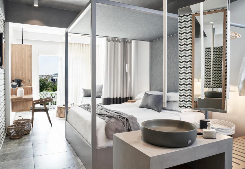a bedroom with a bed and a sink in a room at Antigoni Seaside Resort in Ormos Panagias