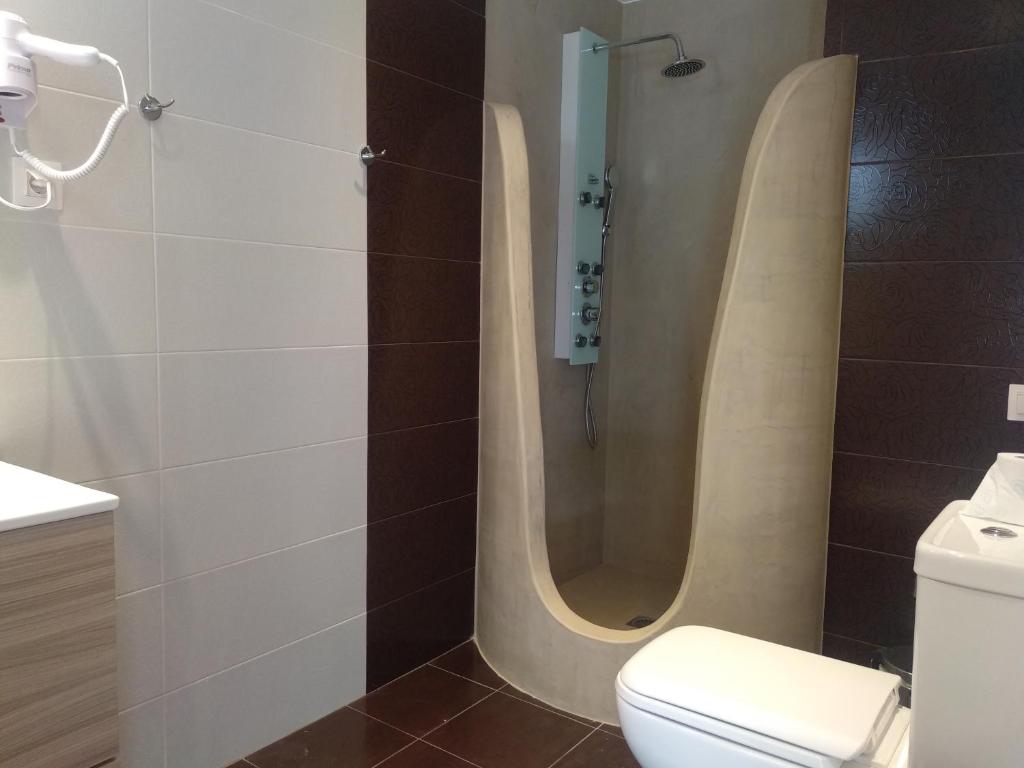uma casa de banho com um chuveiro e um WC. em Hidden garden Deluxe em Skiathos Town
