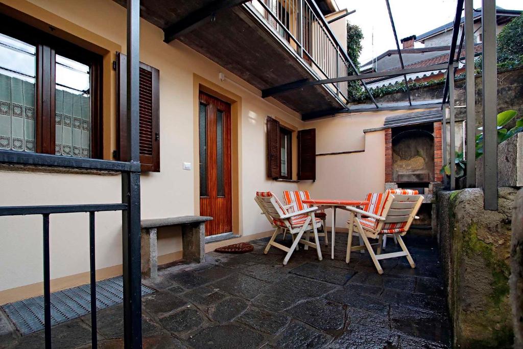 a patio with a table and chairs and a fireplace at Il Giardino Segreto in Luino