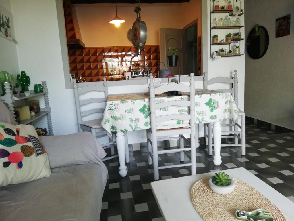 un soggiorno con tavolo e sedie bianche di CAN CACTUS GARRIGUELLA a Garriguella