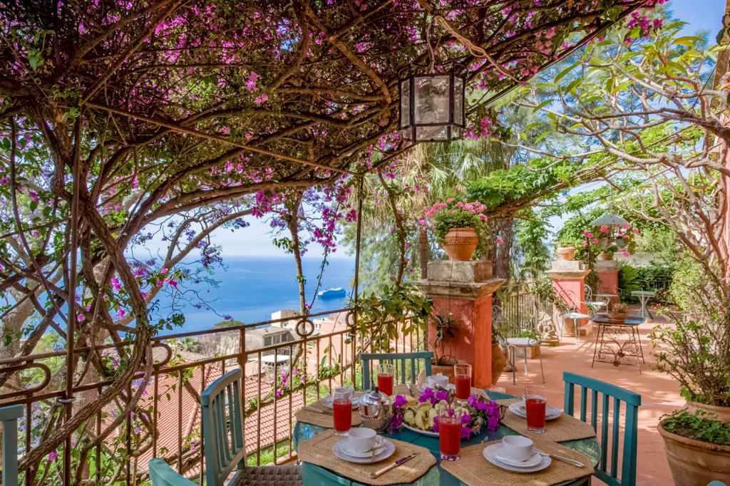 eine Terrasse mit einem Tisch und Meerblick in der Unterkunft Villa Gemmellaro in Taormina