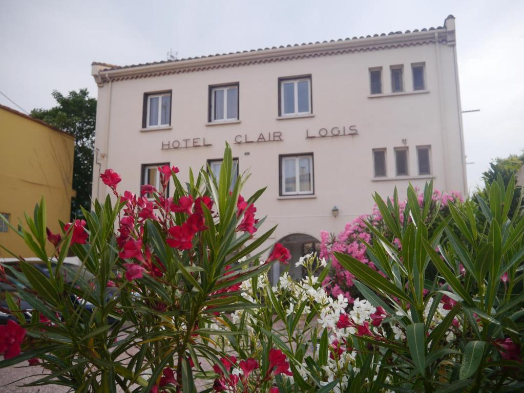 ein Hotelgebäude mit Blumen davor in der Unterkunft Hotel Clair Logis in Argelès-sur-Mer
