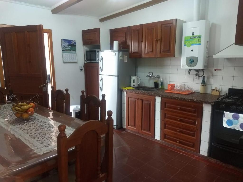 a kitchen with a table and a white refrigerator at Ksa en la Linda in Salta