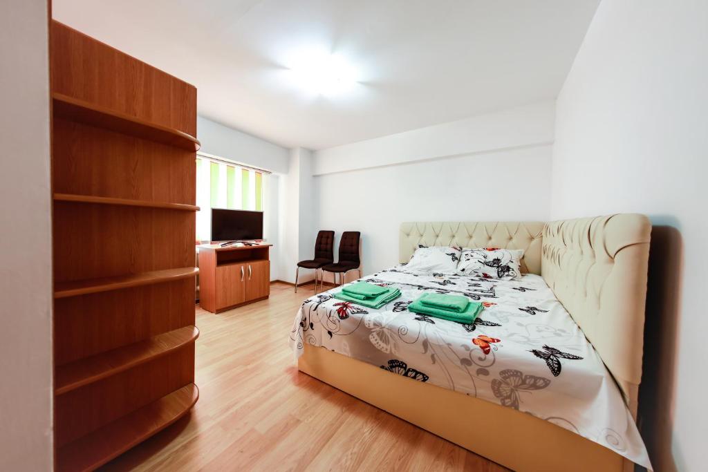 - une chambre avec un lit, un bureau et une télévision dans l'établissement Luxury Radox Apartment Buzau City Center, à Buzău