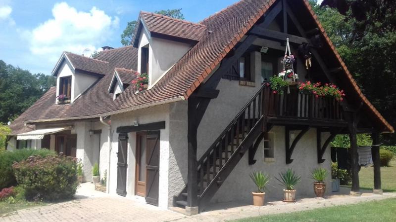 ein Haus mit Blumen auf der Vorderseite in der Unterkunft à l'orée du bois in Bois-Jérôme-Saint-Ouen