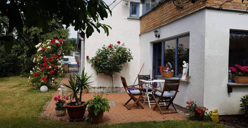 een patio met een tafel, stoelen en bloemen bij Hering FeWo I Apartment Terrace in Wiek auf Rügen 