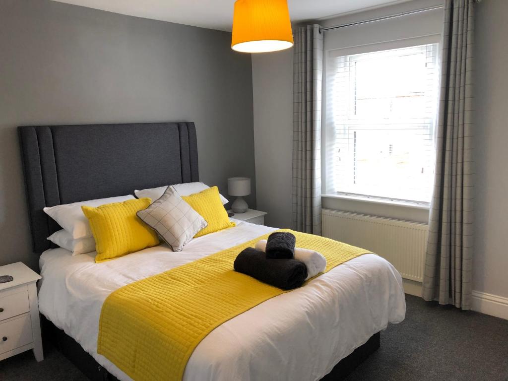 1 dormitorio con 1 cama grande con manta amarilla en Archie's Cottage en Lincoln