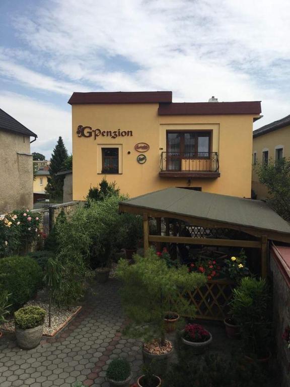 a building with a garden in front of it at G Penzion in Spišská Belá