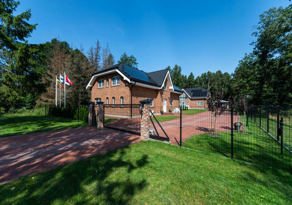 a house with a fence and a tennis court at VILLA AIDO in Palanga