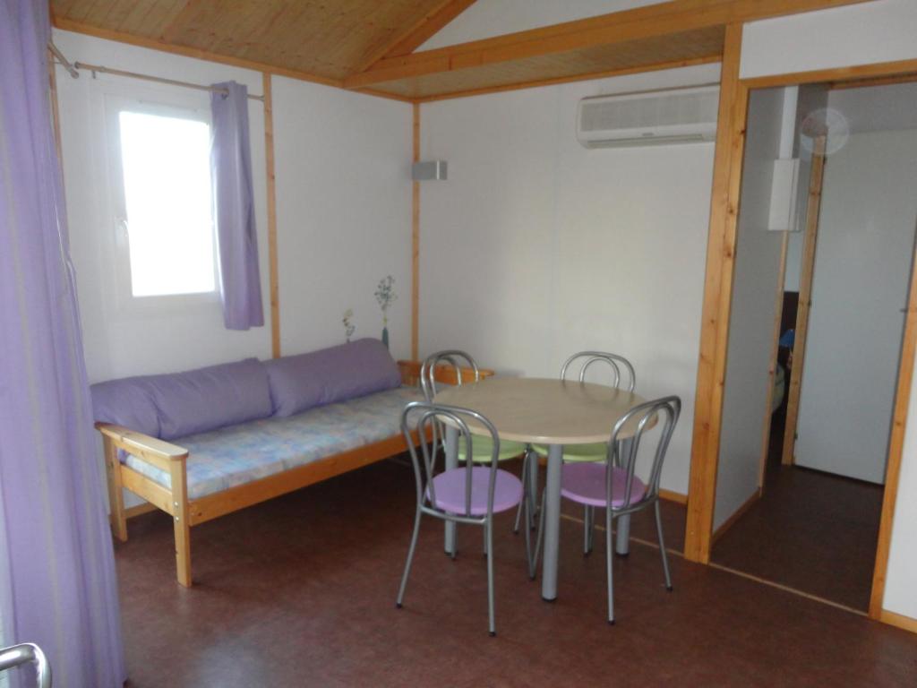 Zimmer mit einem Tisch, Stühlen und einem Sofa in der Unterkunft clos du celine in Castillonnès