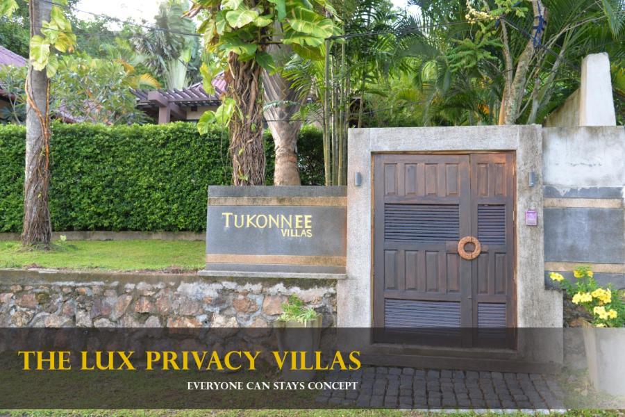 una señal para las villas de la privacidad lamer con una puerta azul en Tukonnee Villas Koh Yao Noi, en Ko Yao Noi