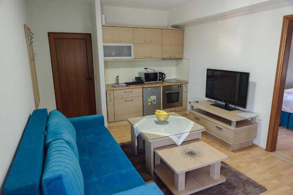 a living room with a blue couch and a kitchen at City Center Apartments in Strumica