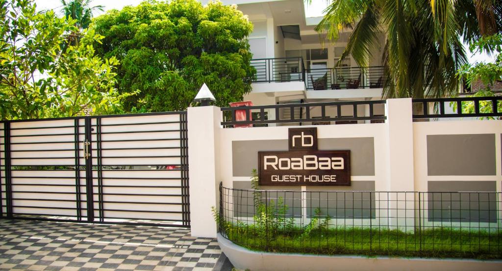 a building with a gate and a sign on it at RoaBaa Guesthouse in Batticaloa