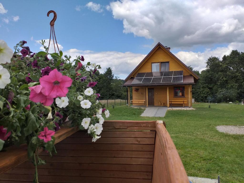 une maison avec un bouquet de fleurs devant elle dans l'établissement Domki całoroczne Bieszczady Panasiewiczówka, à Odrzechowa