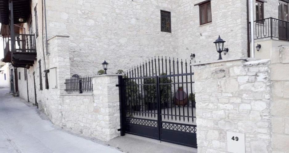 una puerta negra en el lateral de un edificio en Omodos Maria's Apartments, en Omodos