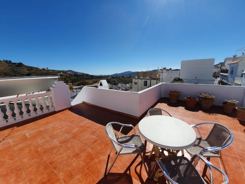 a patio with a table and chairs on a balcony at Casa Hadriano in Cómpeta